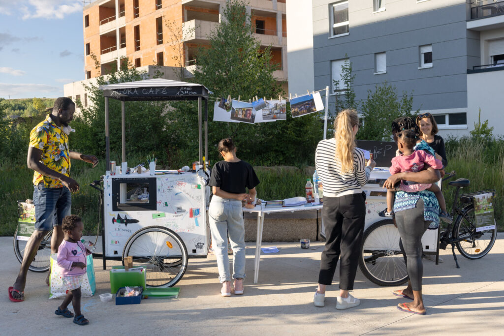 The Remix Place Agora Cafe installation as installed in the Audun-le-Tiche Ecopark. People gather around pop-up coffee carts.