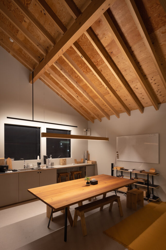 A contemporary kitchen with a high ceiling in the Ishinomaki Laboratory Home Base.