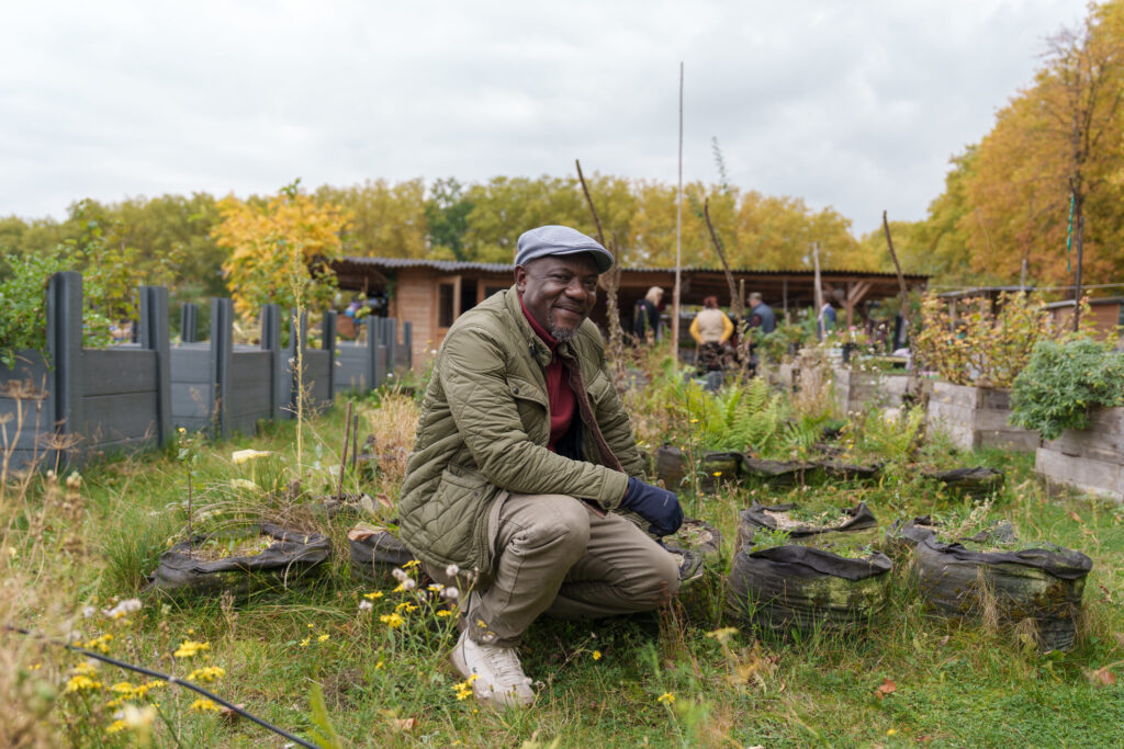 A portrait of a man in a community garden.
