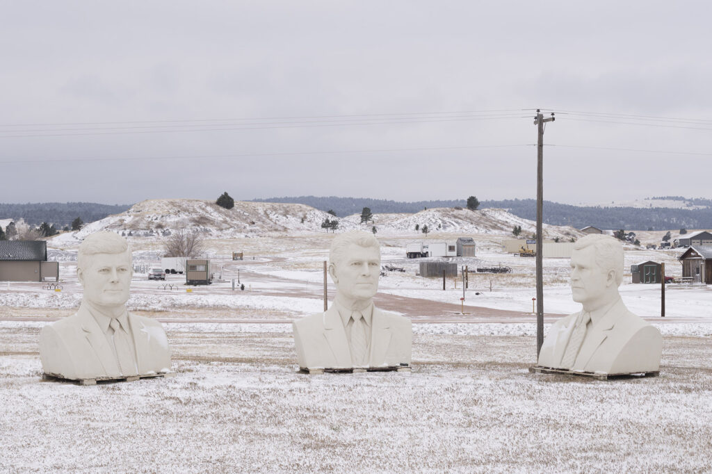 Giant busts of U.S. Presidents in a snowy field.