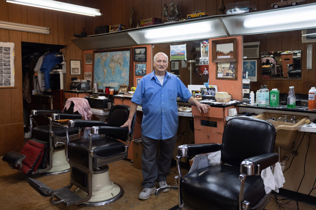 A barber standing in his shop in Columbus, Indiana.